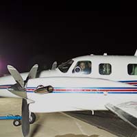 Pilot in aircraft on tarmac at night