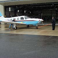 Small aircraft being moved out of hangar