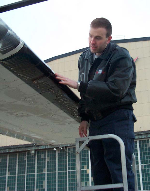 Pilot performs tactile inspection on high wing aircraft
