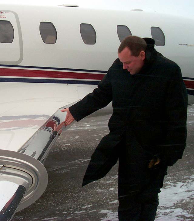 Pilot performs tactile inspection of wing – pre-spray