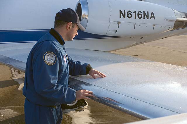 Pilto checking aircraft wing for frozen contamination
