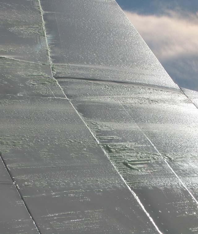 Residual anti-icing fluid frozen on wing in flight